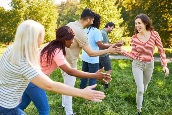 Benefits of team building featuring a team collaborating and having fun outside