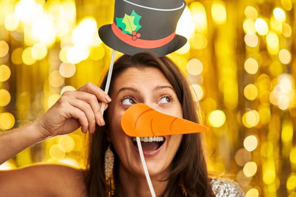 Colleague enjoying festive photo booth, one of the best Work Christmas Party Ideas